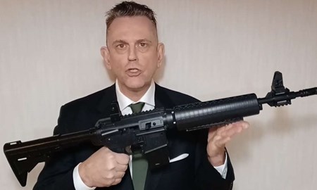 L-politikern poserar med vapen: